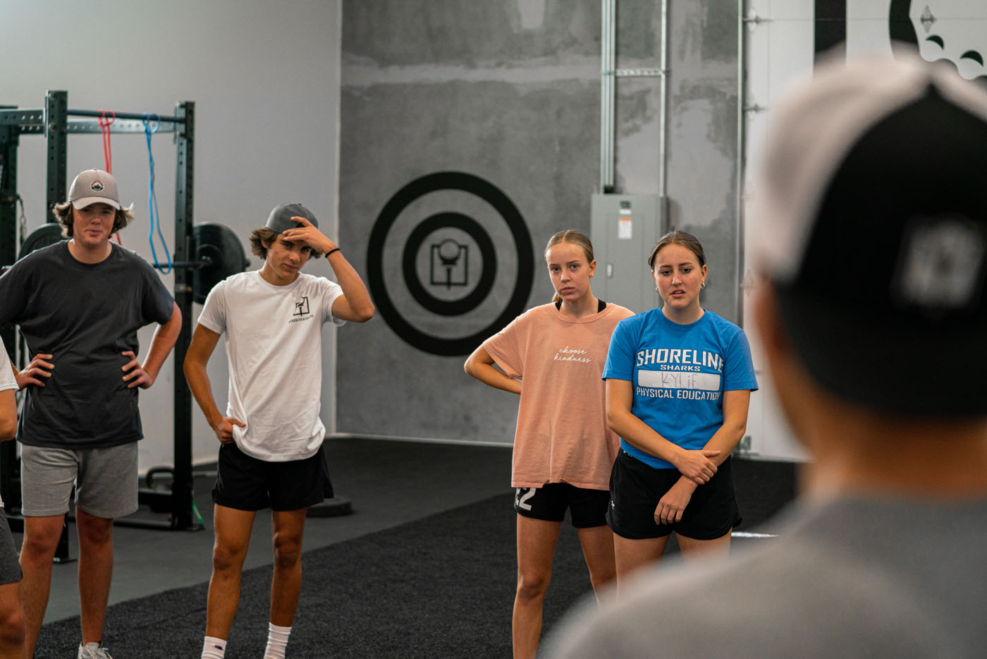 A group of teens recieving personalized golf training at a Tee Box indoor golf course.